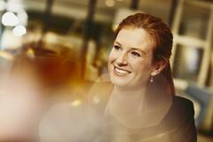 Business woman smiling. Primary colors: white and yellow.