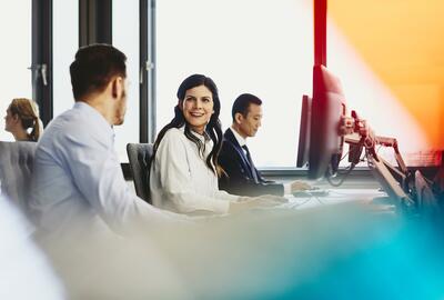 People working in their desks. Primary colors: blue and yellow.