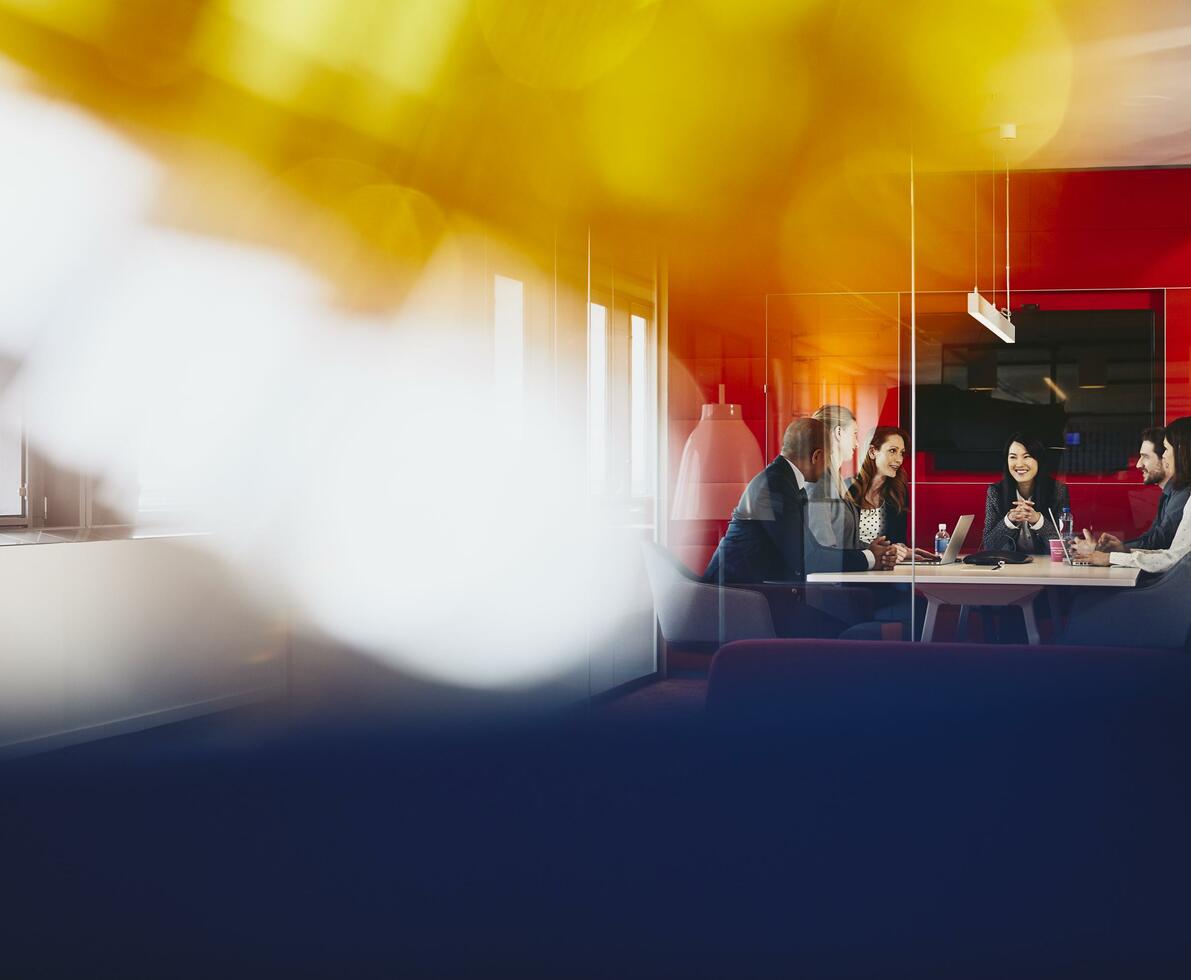 Group of business people having a meeting in an office. Primary colors: blue and yellow.