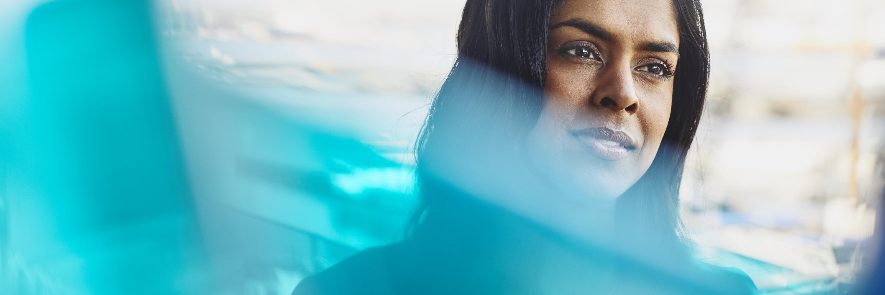 Young woman in harbor. India. Primary color: blue.